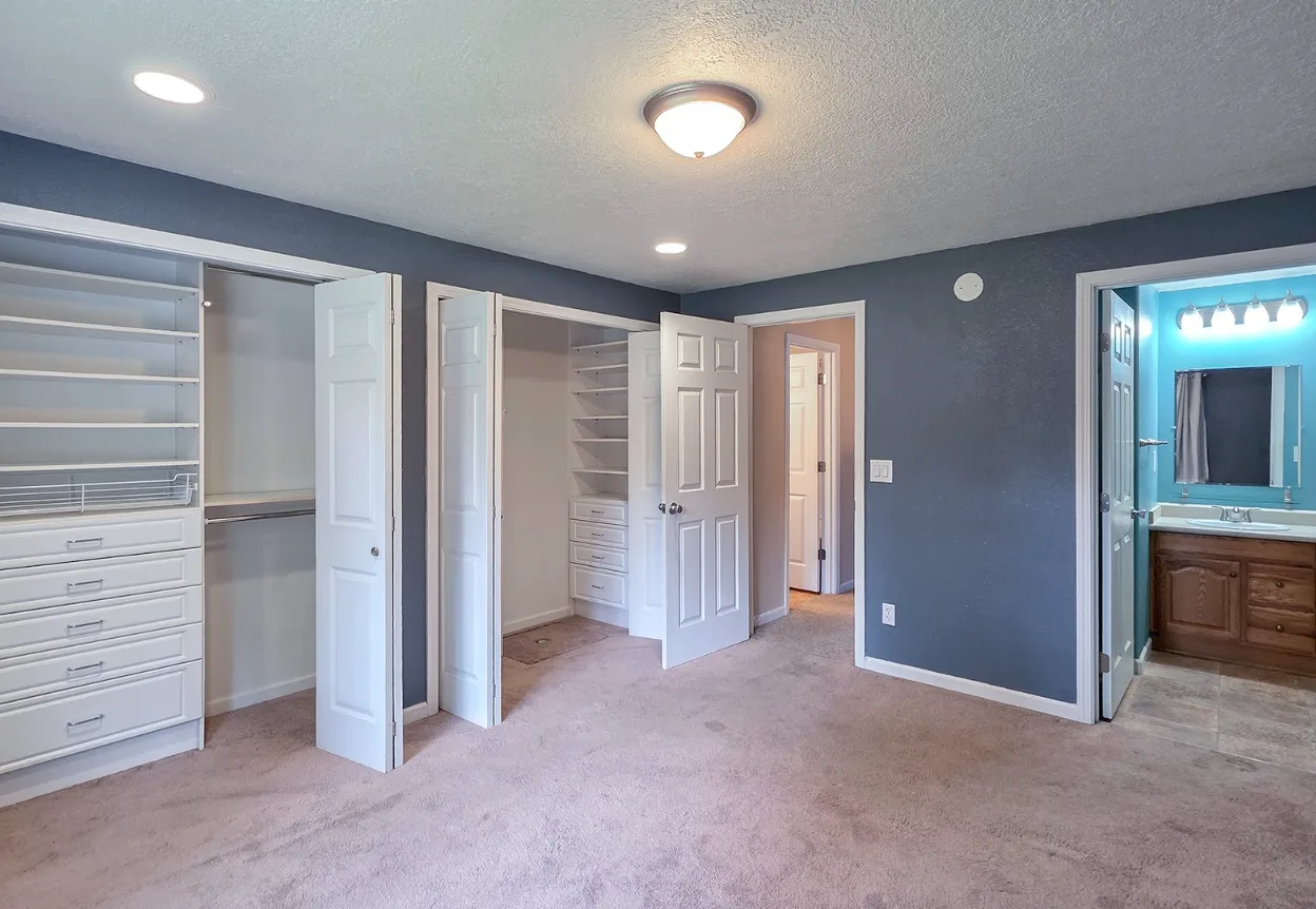 Master bedroom with walk-in closets and built-in shelving