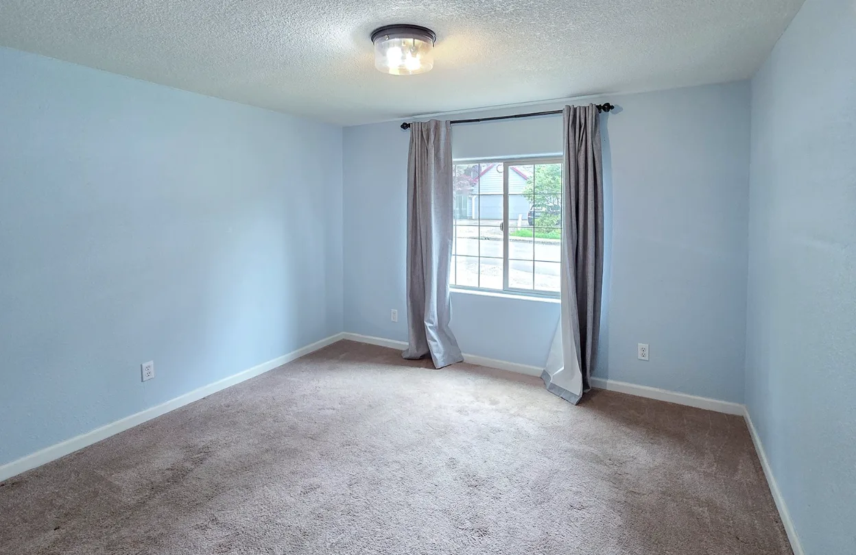 Secondary bedroom with blue walls and beige carpet