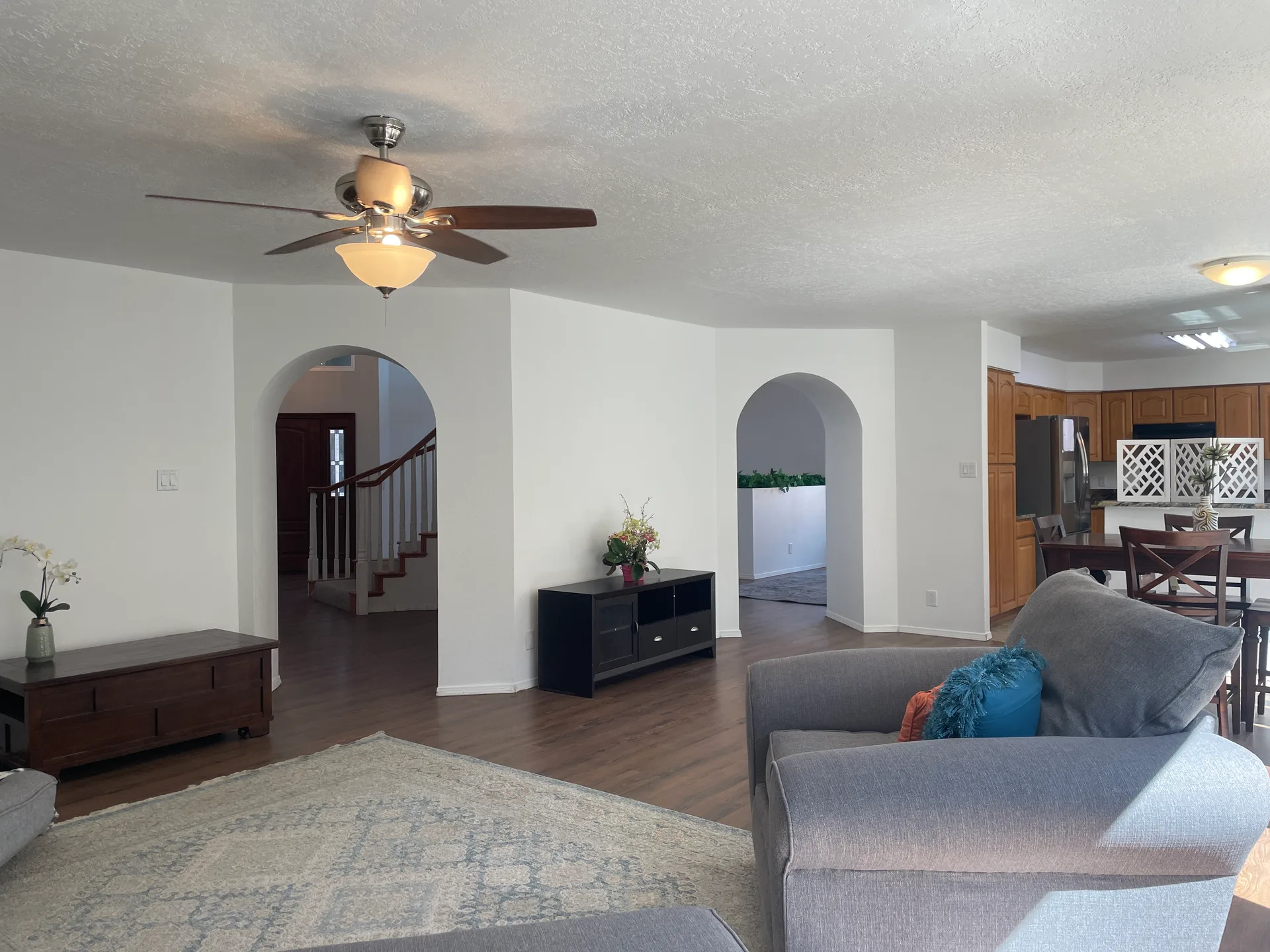 Living room with archway transitions to the entryway and kitchen