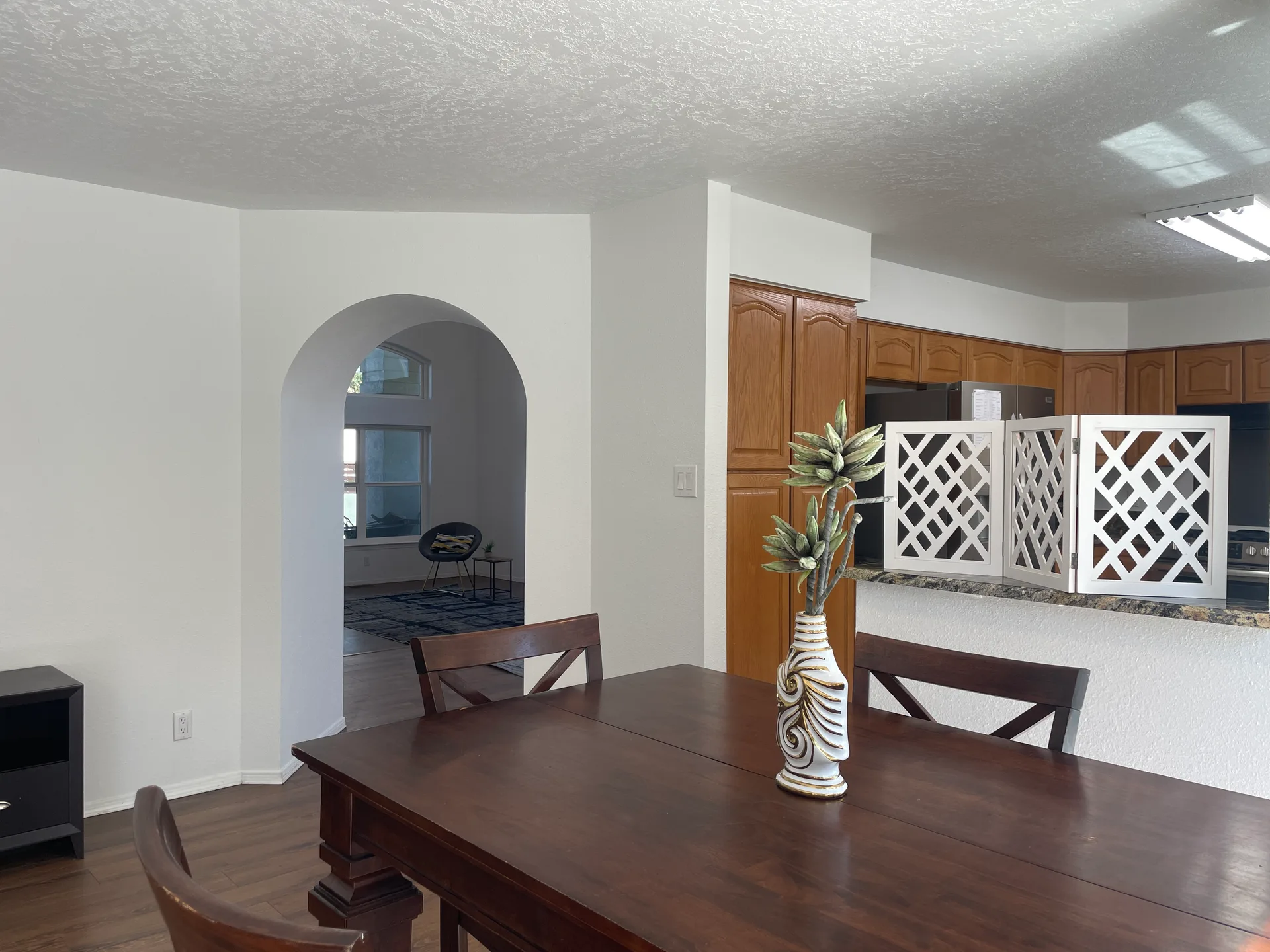 Dining area with an arched doorway opening to the kitchen and living spaces