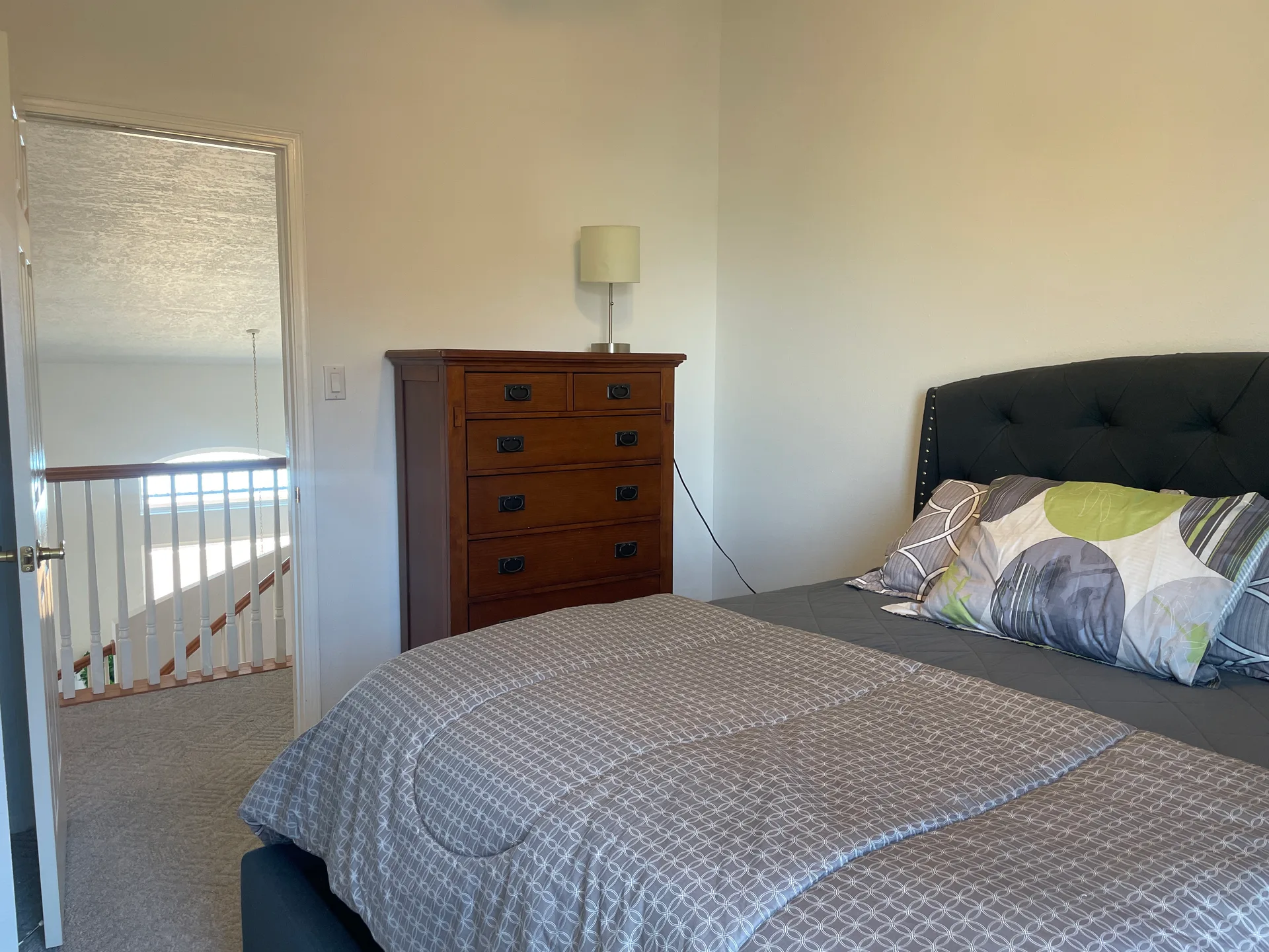 Guest bedroom upstairs with carpeted floors and neutral walls