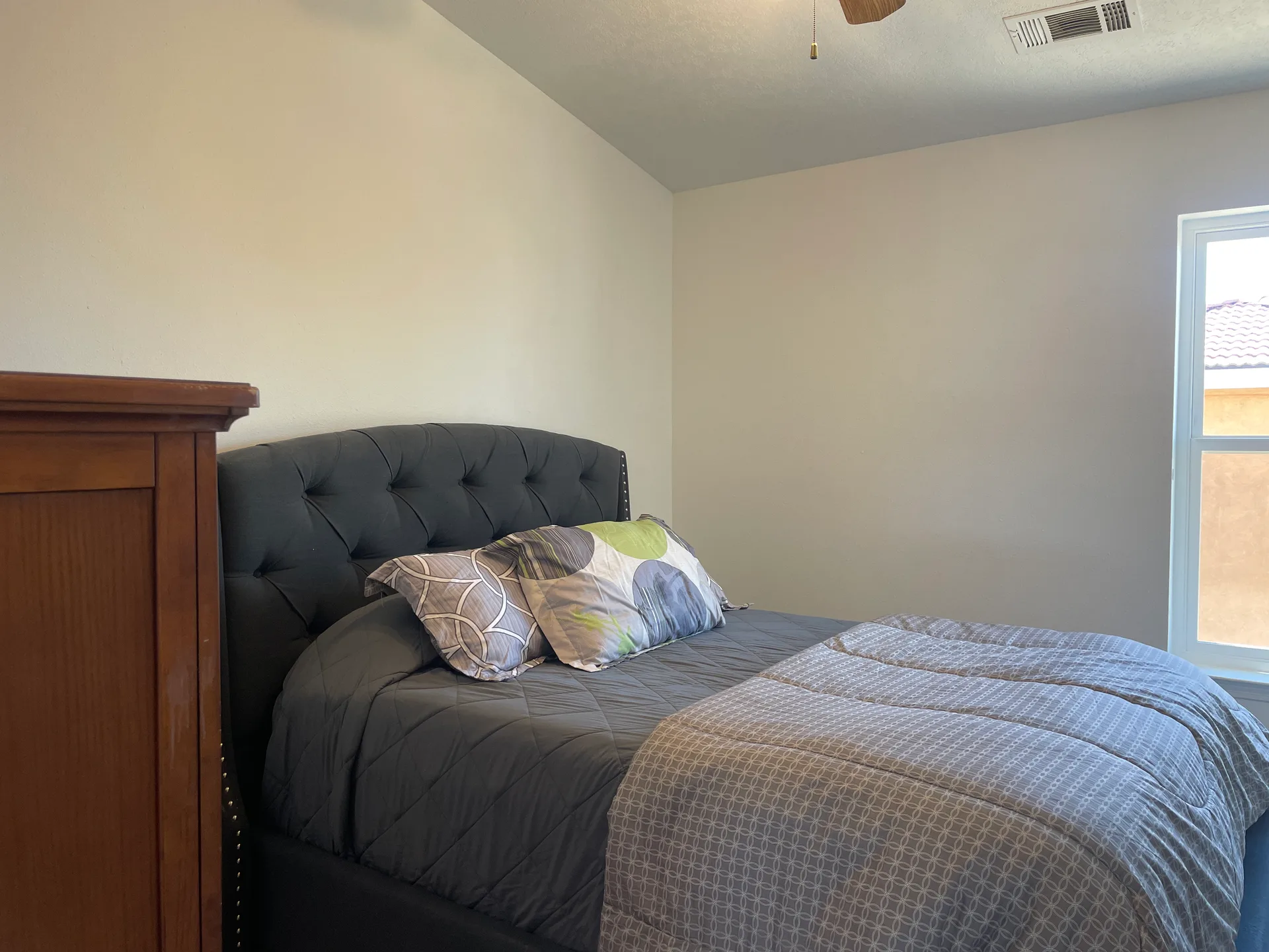 Secondary bedroom with a window, neutral walls, and carpeted floors