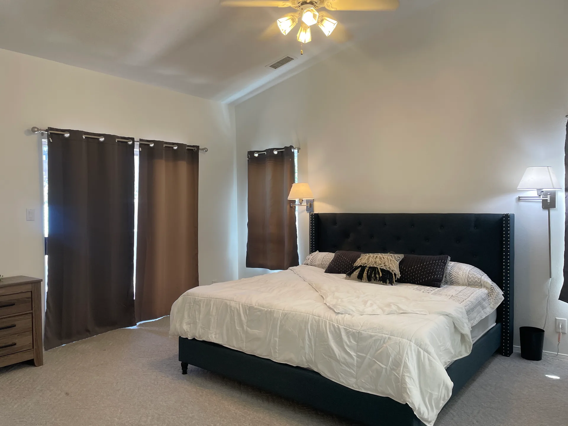 Master bedroom with vaulted ceiling, window, and neutral wall color