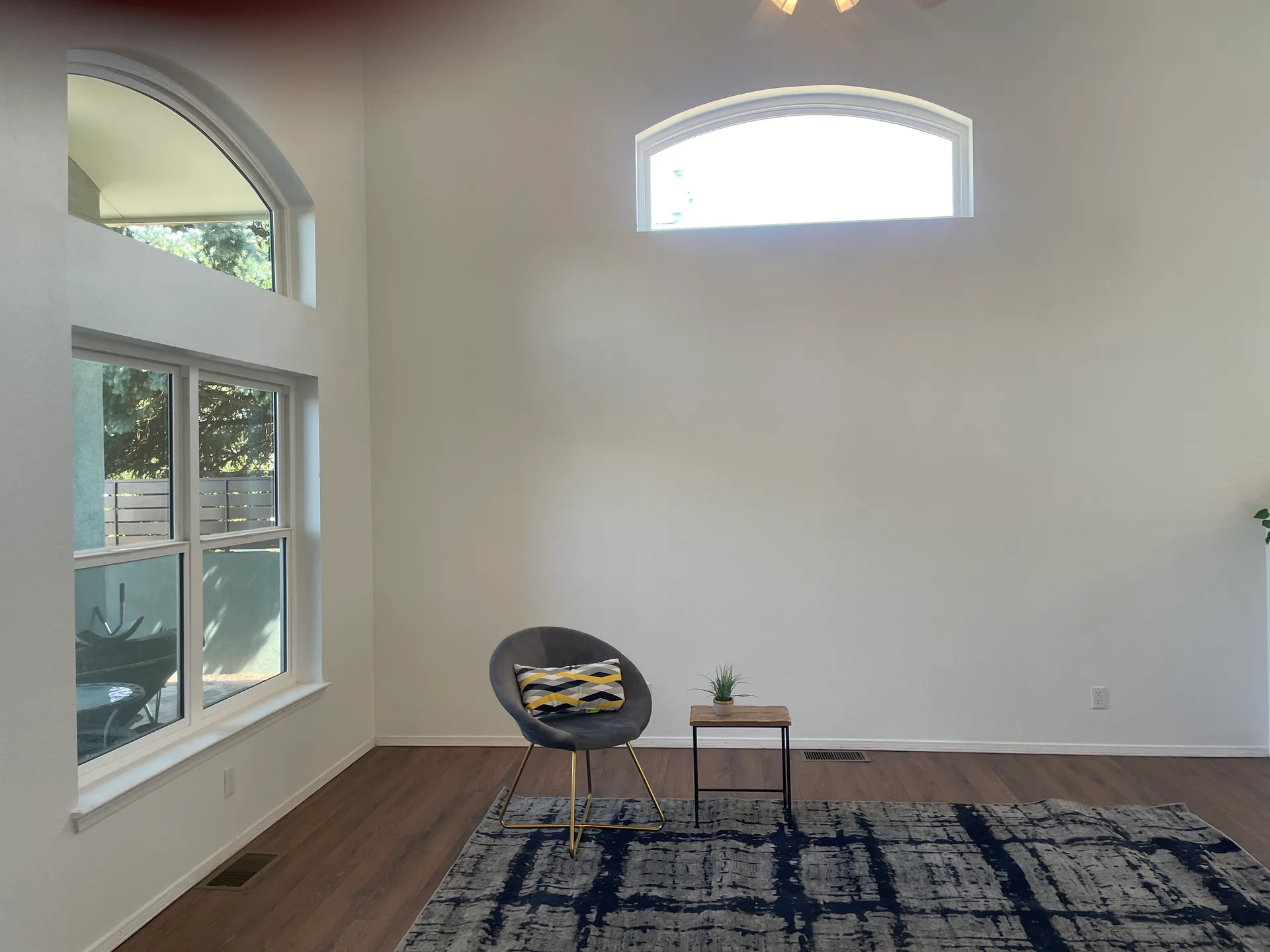 Living room with high ceilings, large windows, and arched transom windows