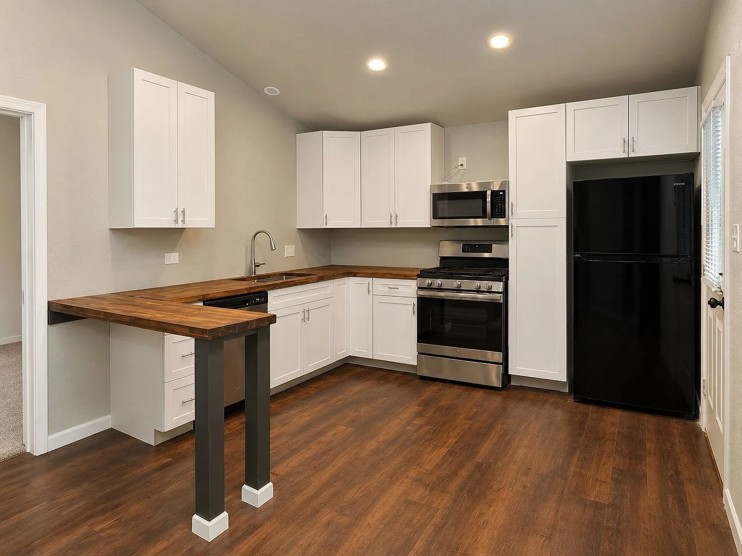 Bright kitchen with white cabinetry and butcher-block countertops