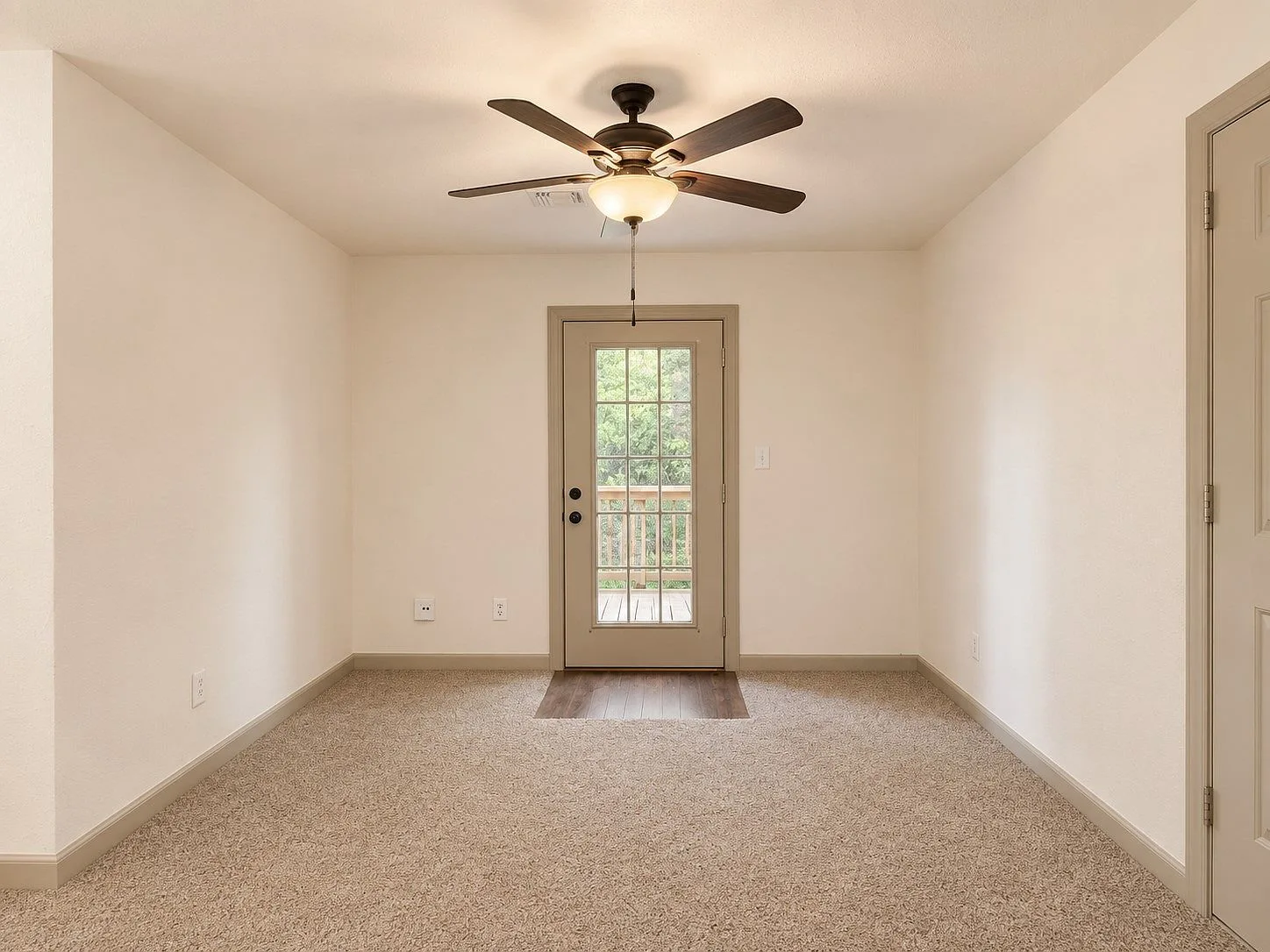 Secondary bedroom with glass-pane door to back deck