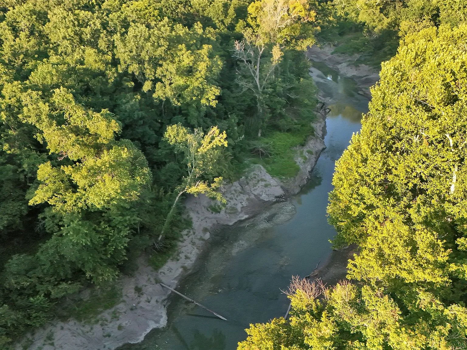 Aerial of river cutting through densely wooded forest