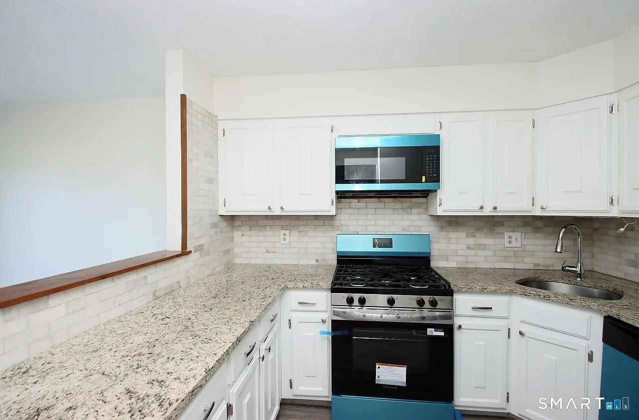 Updated kitchen with granite countertops and subway tile backsplash