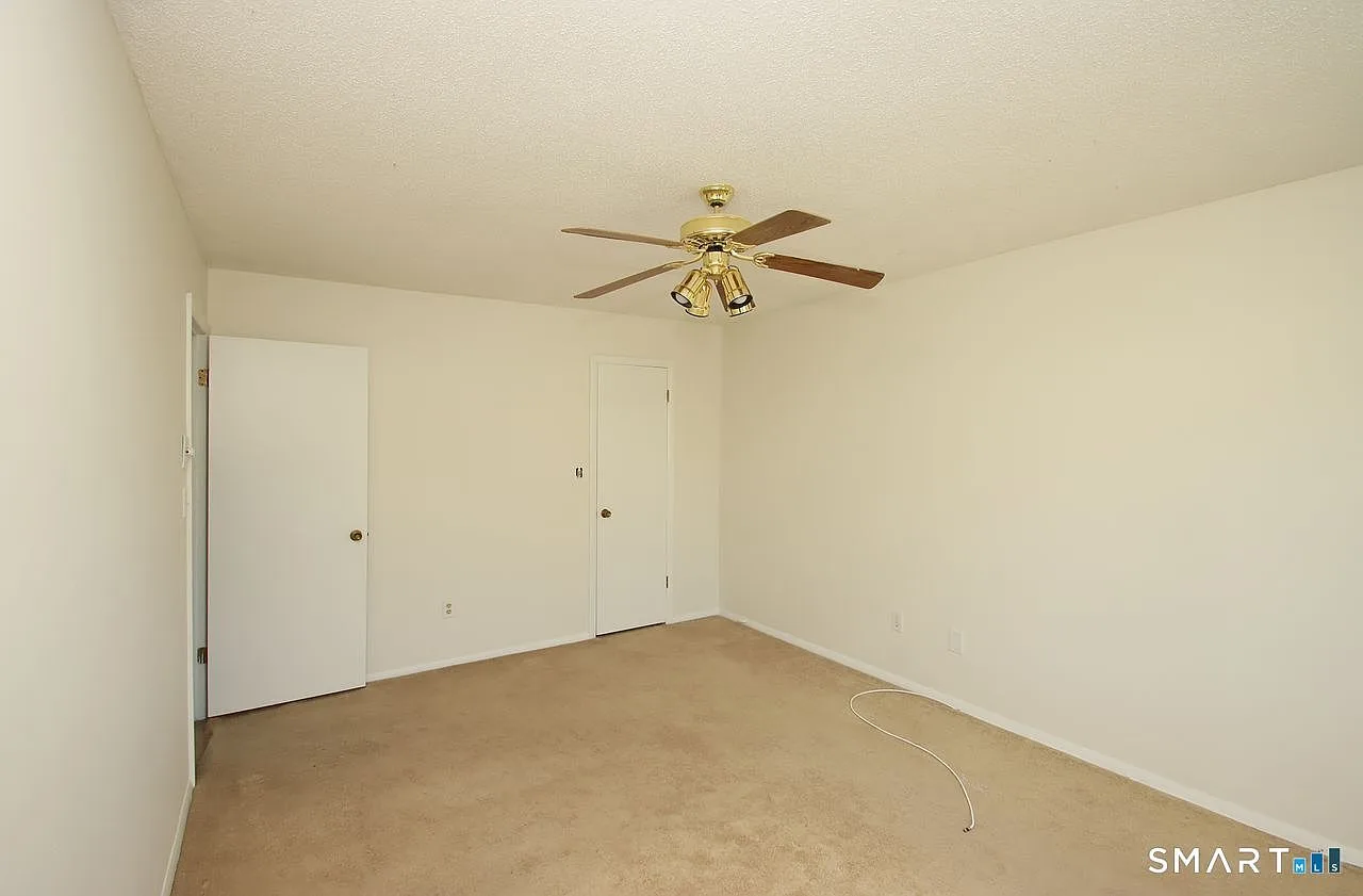 Secondary bedroom with beige carpeting and white doors