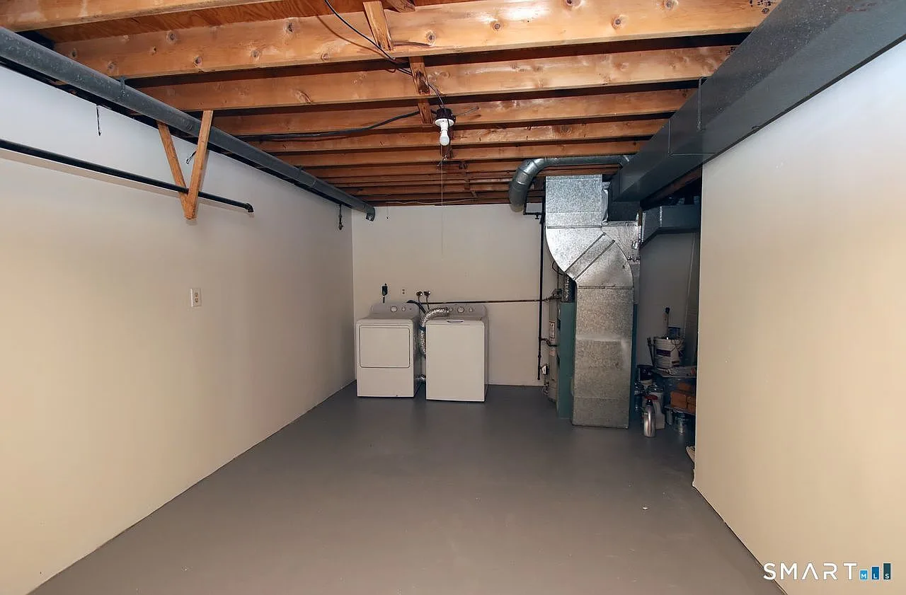 Unfinished basement utility area with washer and dryer