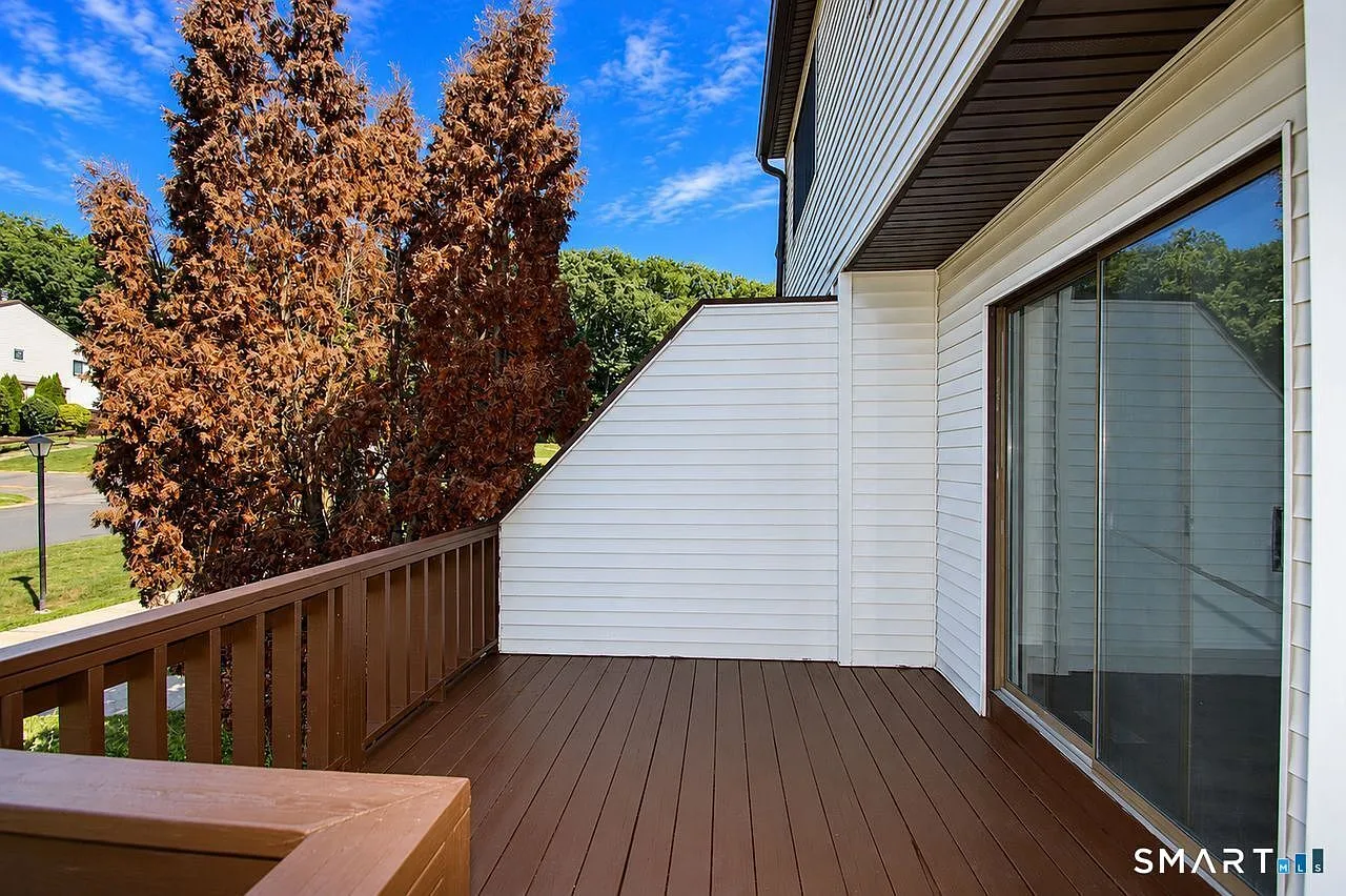 Private condo deck with brown wooden railings