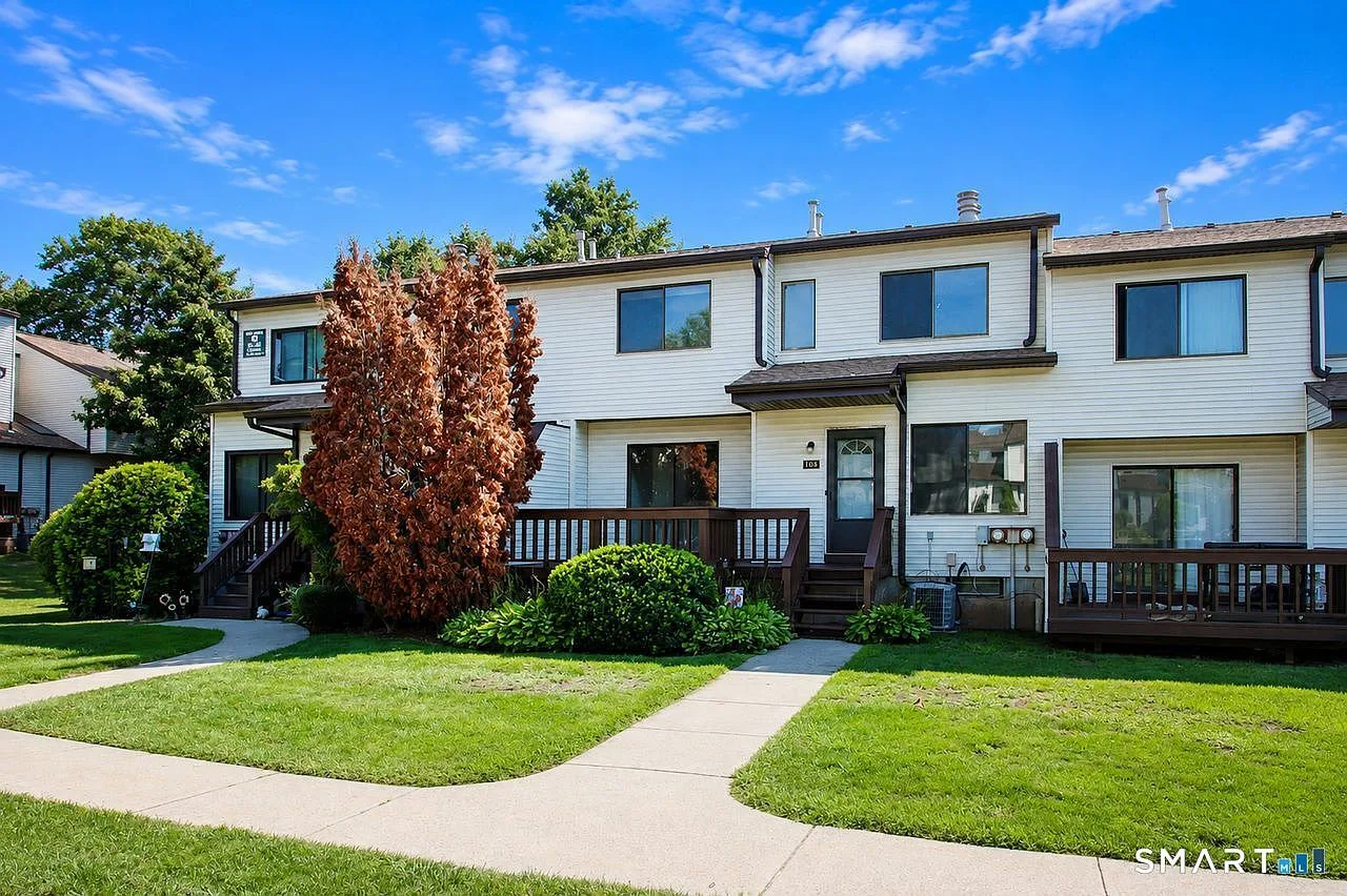 Exterior view of the townhouse-style condo with green lawns