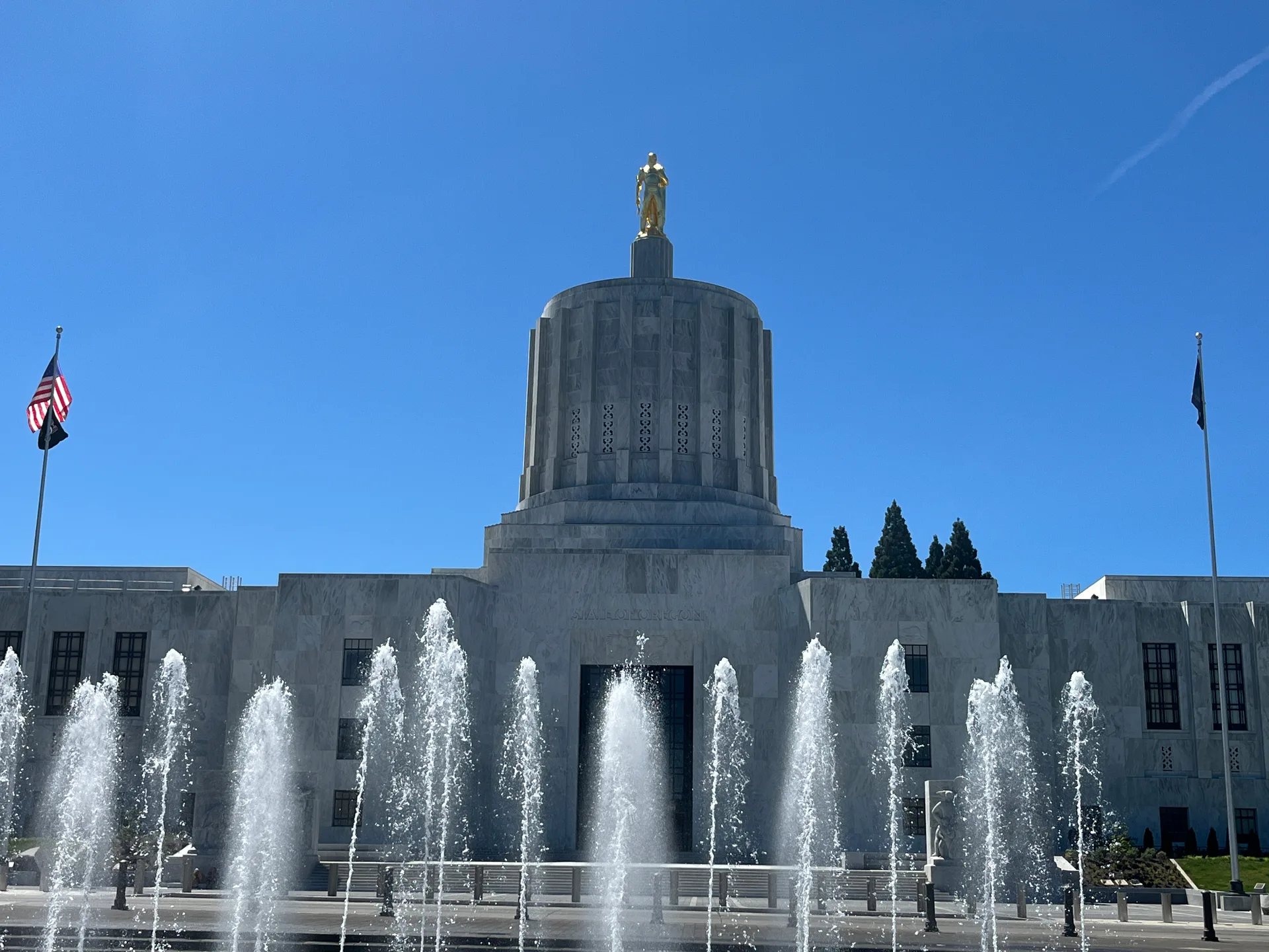 Oregon State Capitol building with its golden-domed tower, flags, and front fountain
