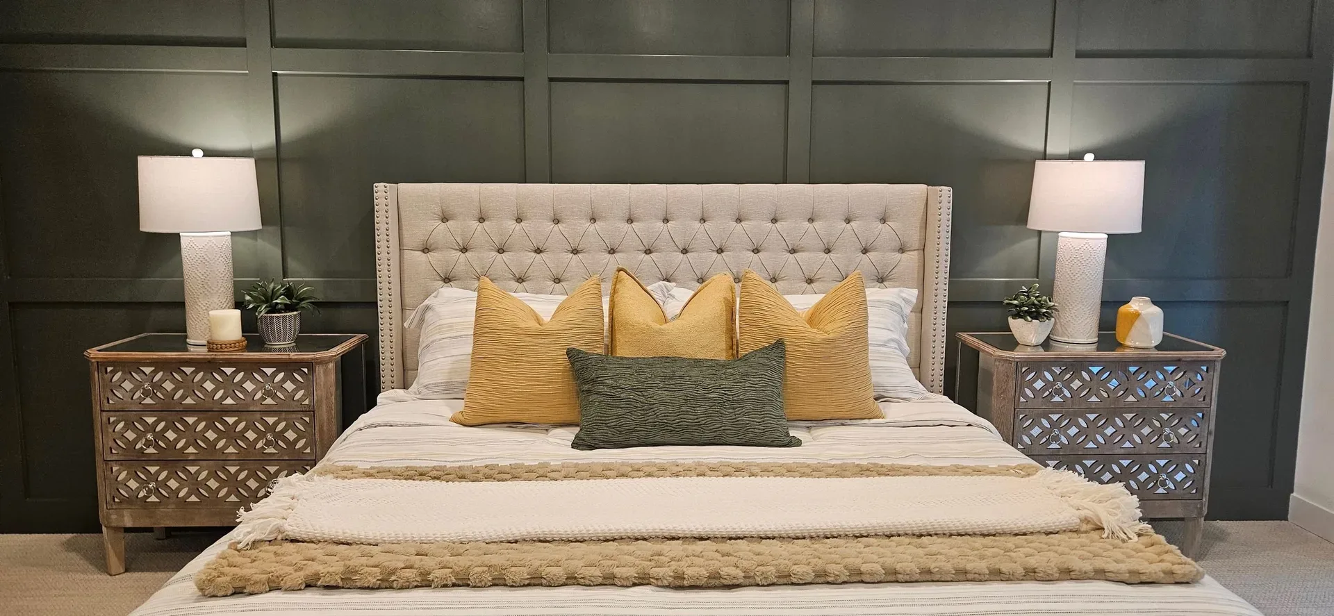 Beautifully staged master bedroom with dark green accent wall, symmetrical bedding, and bedside lamps