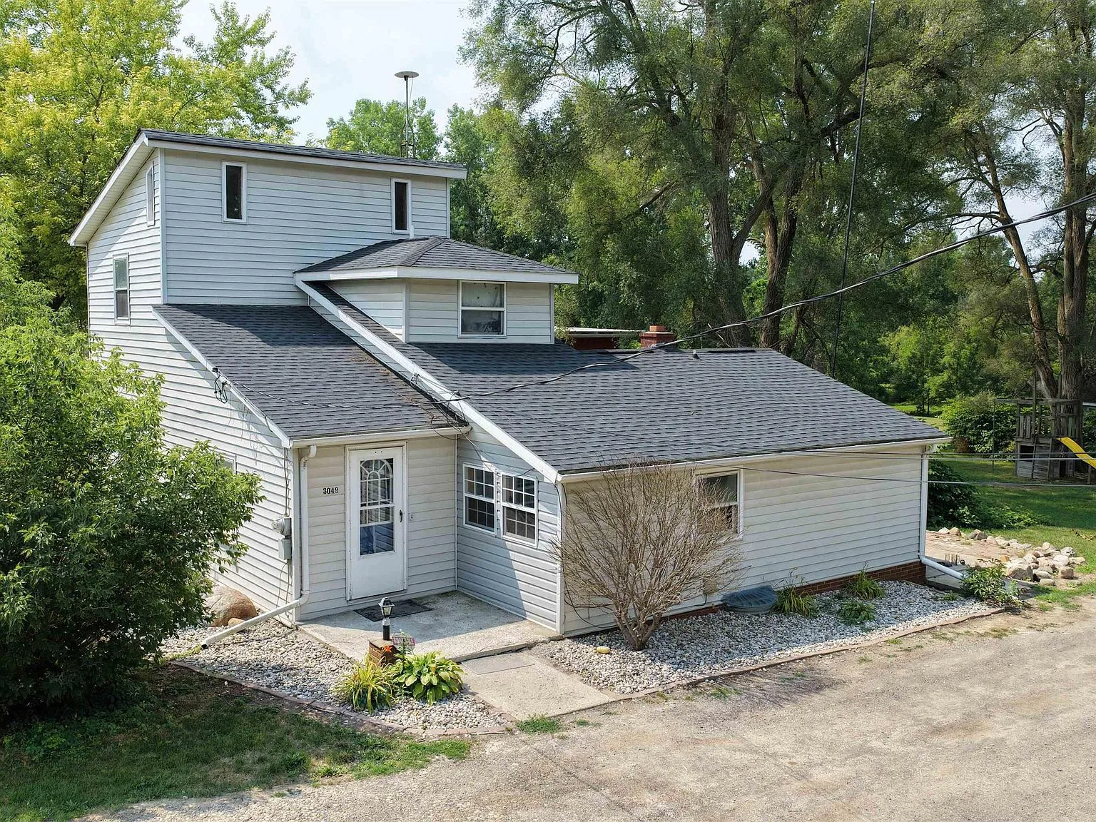 Front exterior of 3049 Egleston Ave, a Cape Cod style home with light gray vinyl siding