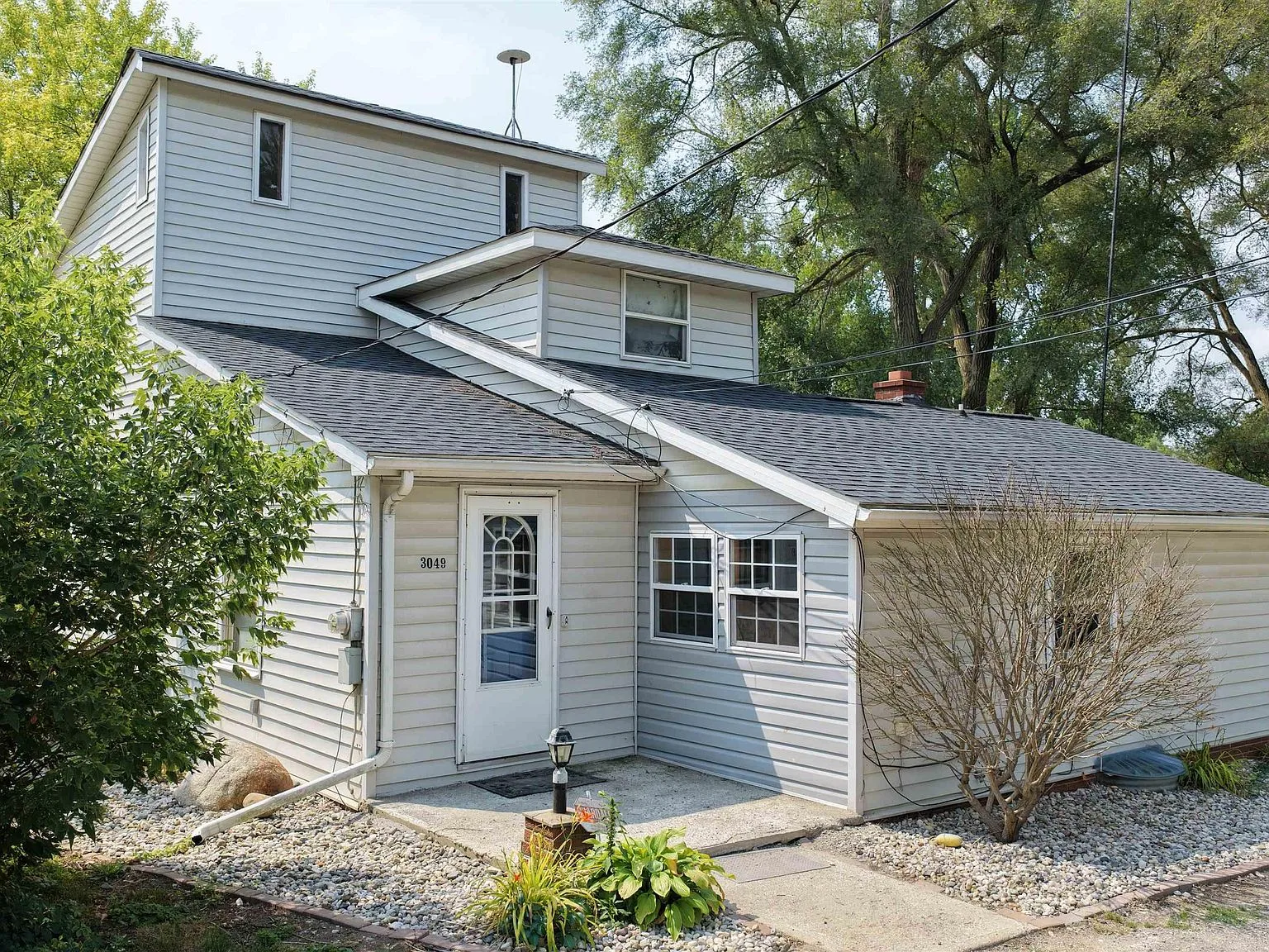 Cape Cod facade with grey vinyl siding and front entry