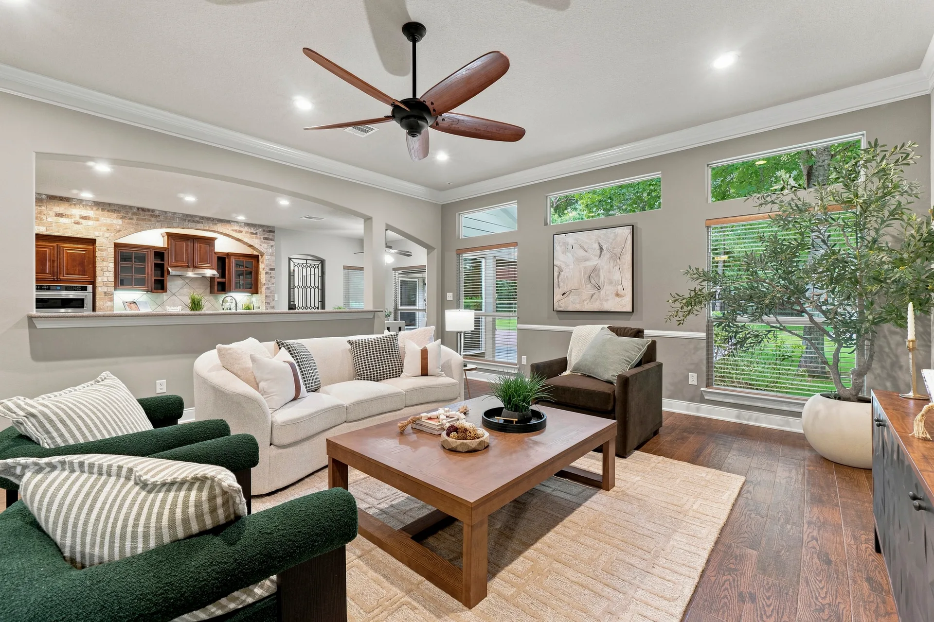 Open-concept living room flowing into the kitchen with hardwood floors and neutral walls