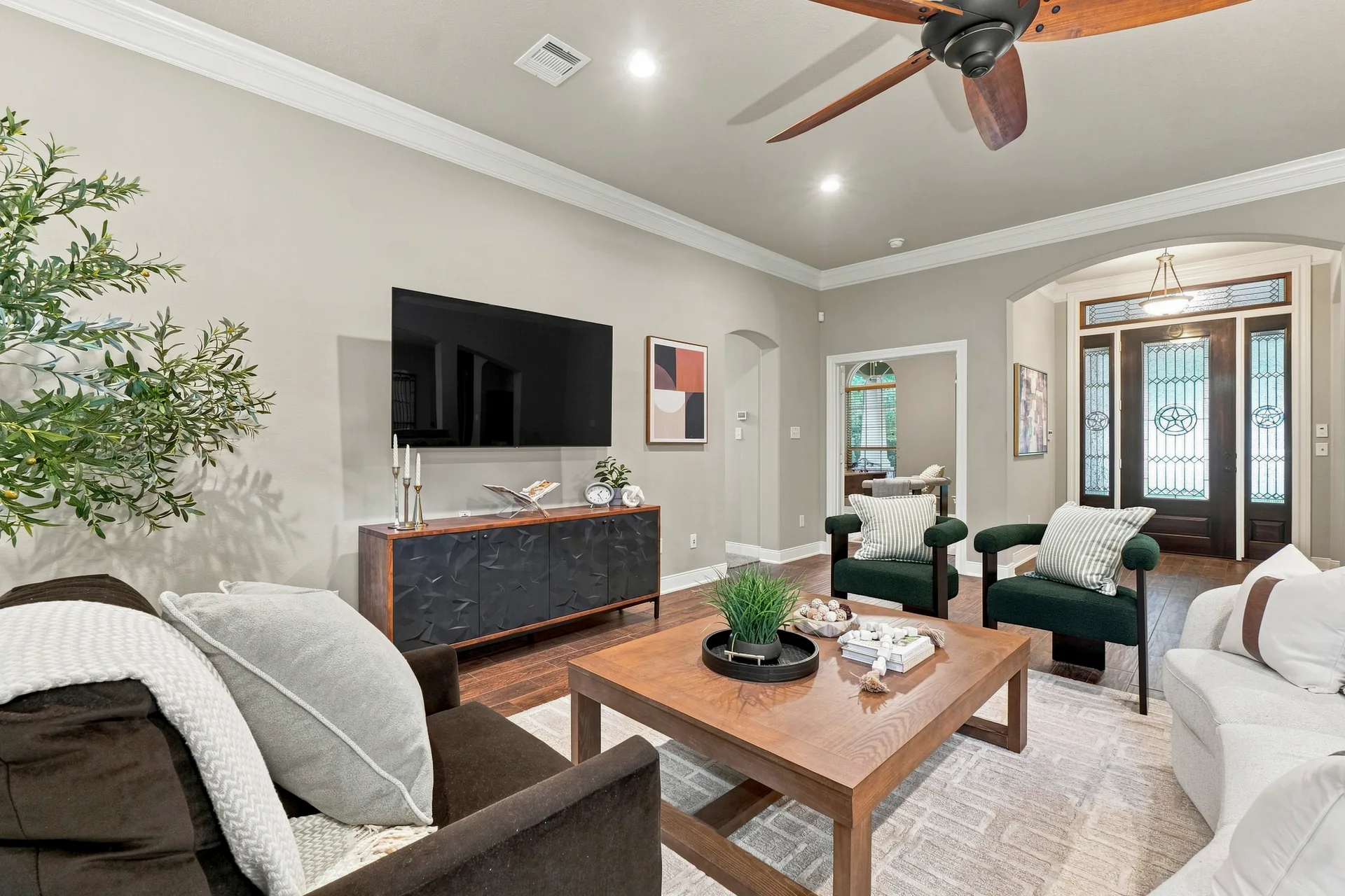 Living room with open-concept floor plan leading to the entryway, hardwood floors, and recessed lighting