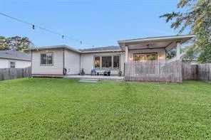 Wide view of the fenced backyard with covered patio, stamped concrete, and plenty of room for a pool