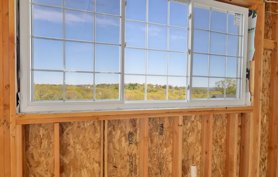 Unfinished room with new window installed showing view of trees outside