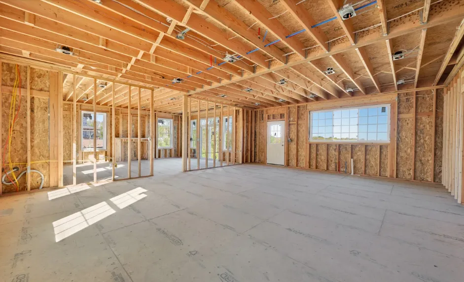 Open floor plan framing with exposed joists and natural light