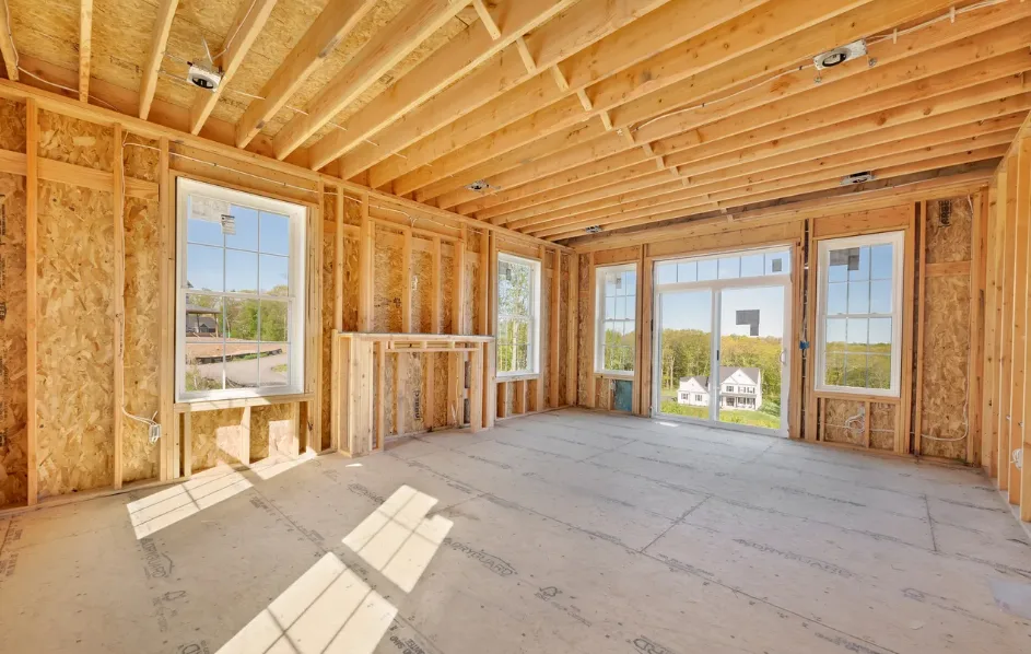 Living room under construction with exposed studs and fireplace structure