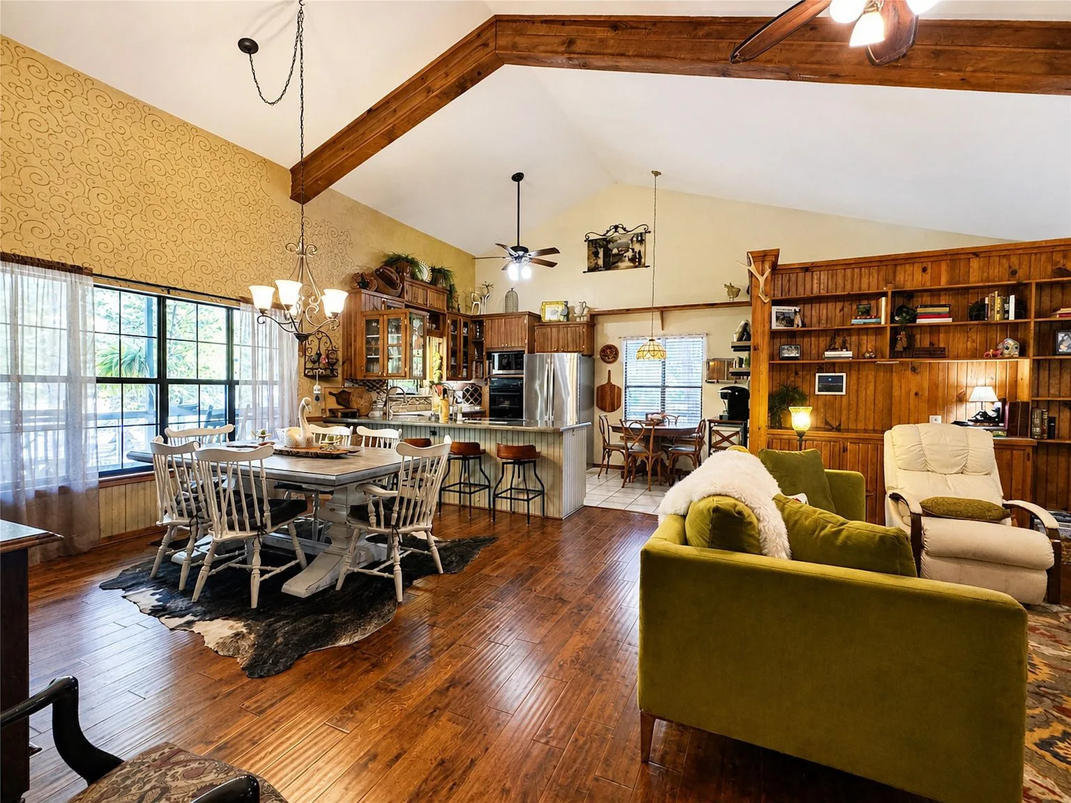 Open-concept living, dining, and kitchen area with vaulted ceiling