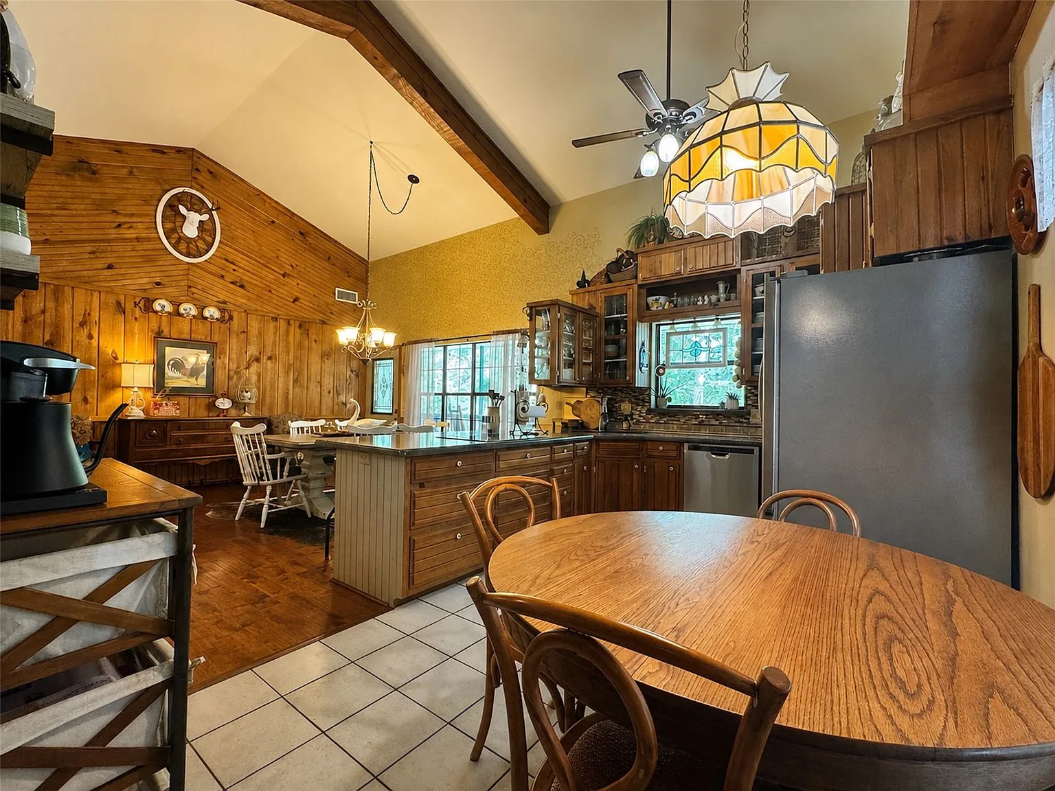 Rustic kitchen with island bar seating and knotty pine paneling
