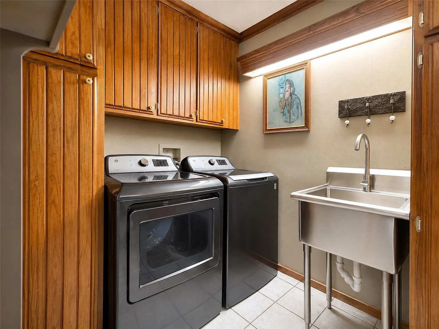 Laundry room with wood cabinetry and utility sink
