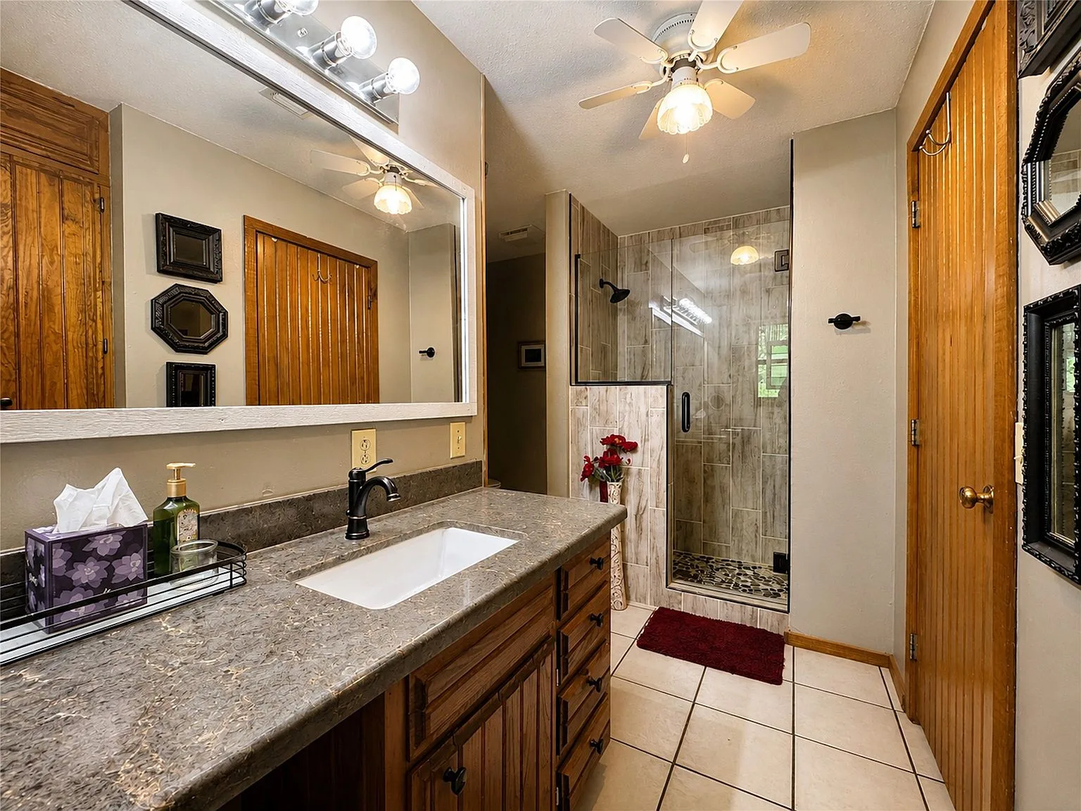Bathroom with stone-look countertop and wood cabinetry