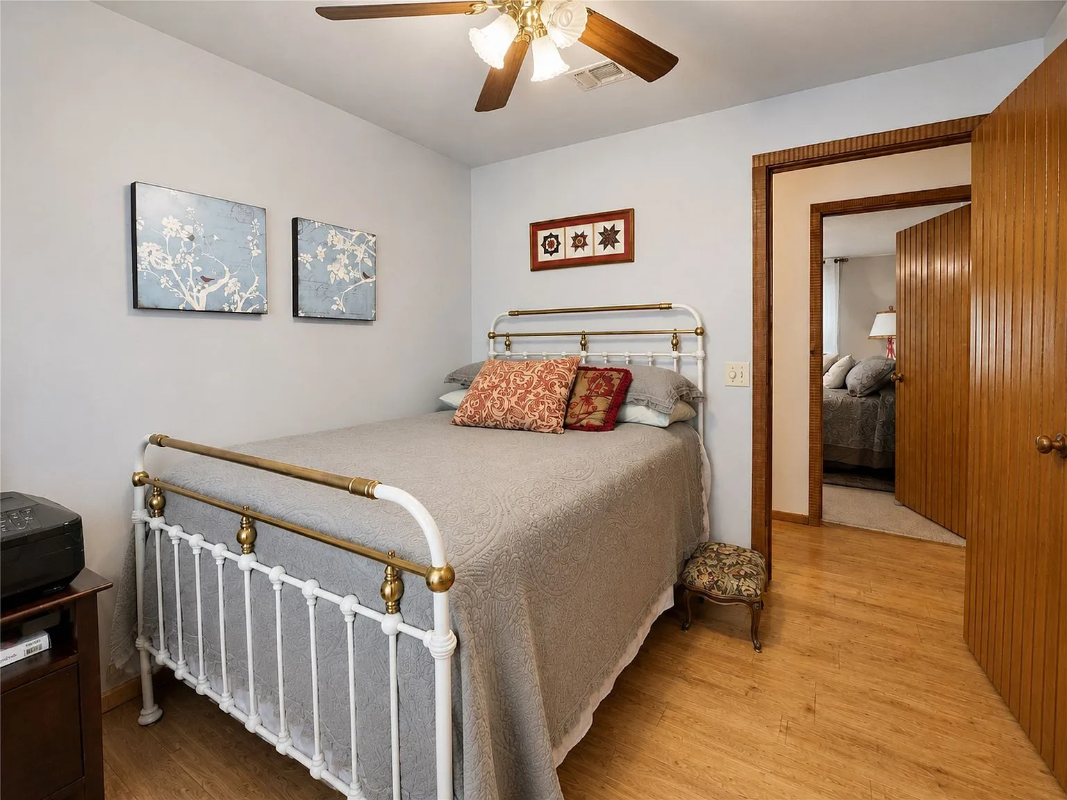 Secondary bedroom with light blue walls and wood laminate flooring