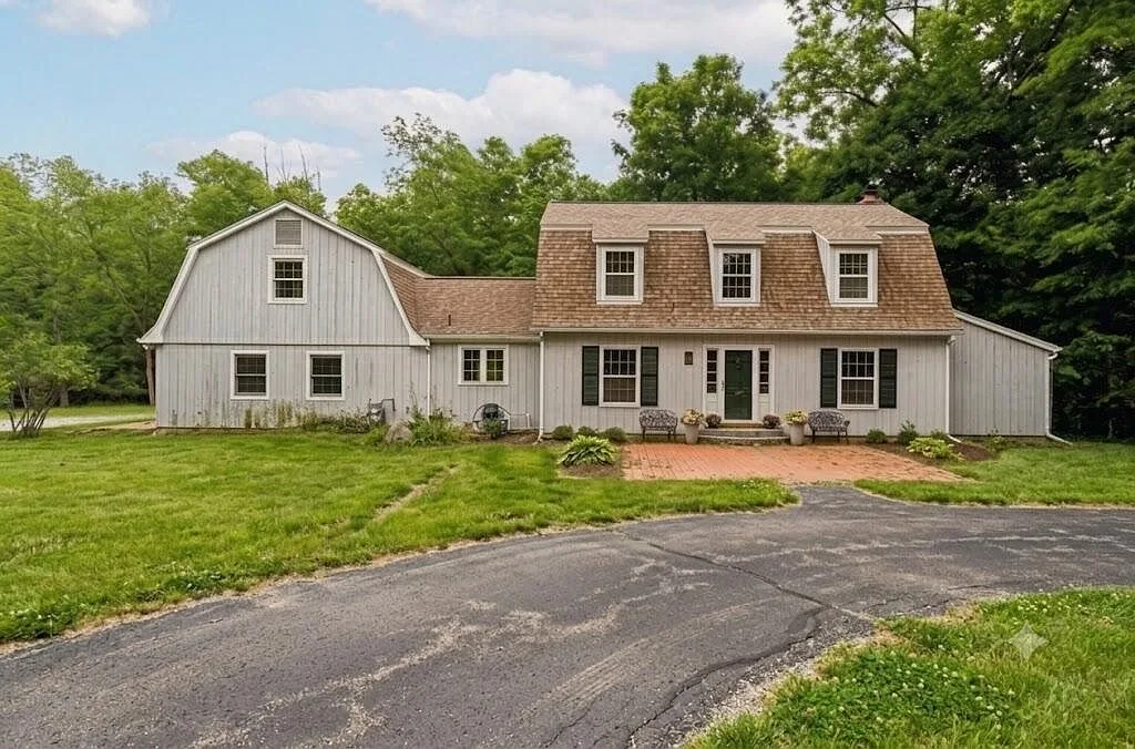 Main house facade with brick patio and bench seating