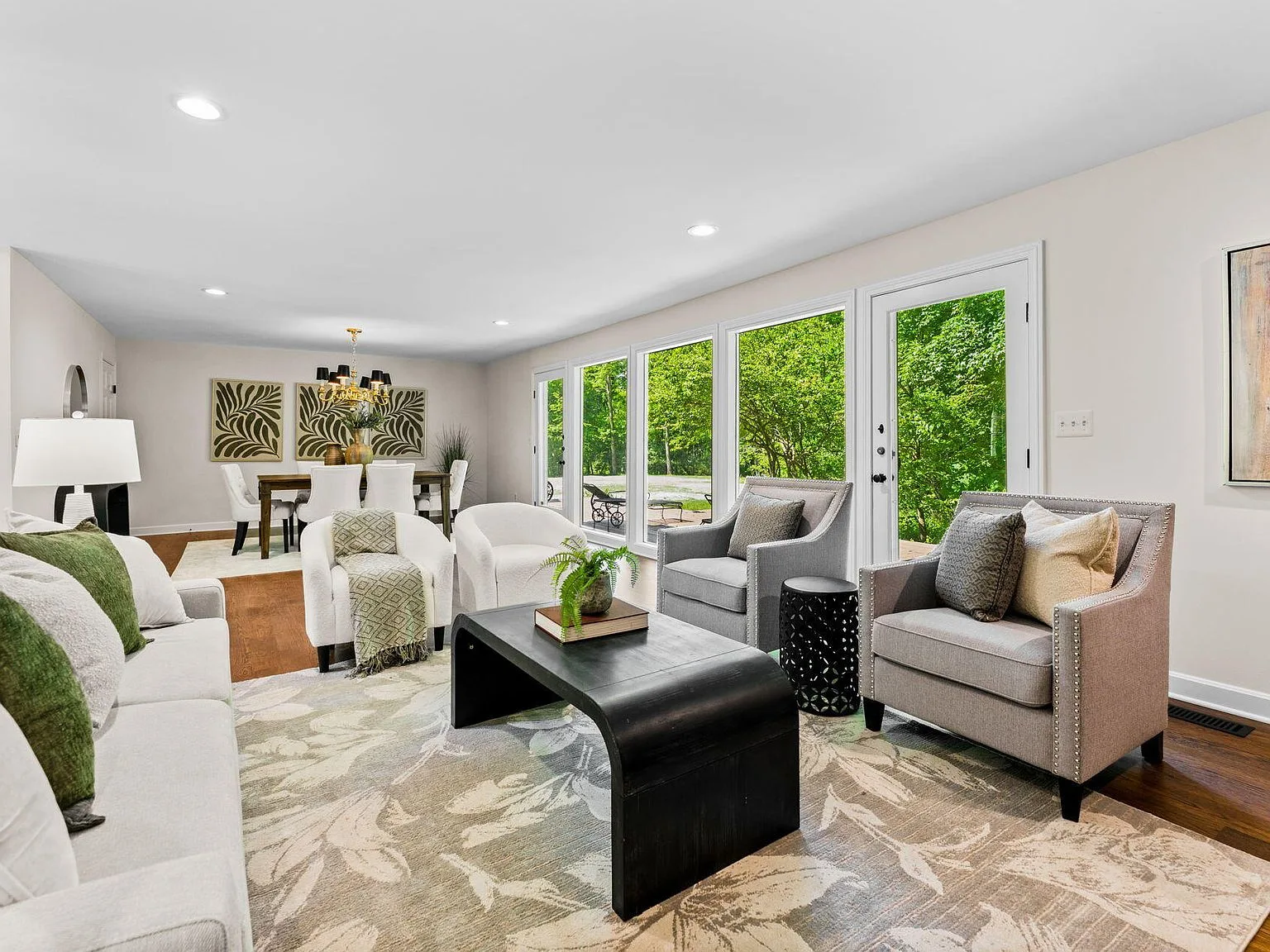 Open concept living and dining area with hardwood floors and deck access