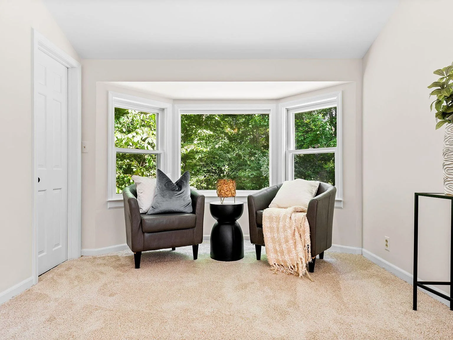 Bedroom sitting area with bay window and wooded view