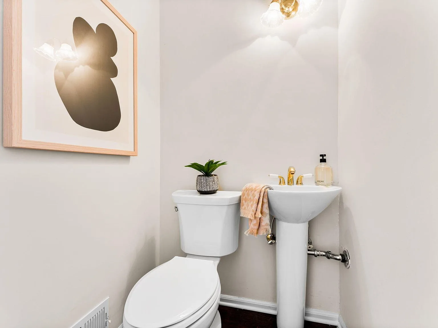 Powder room with pedestal sink and dark hardwood floors