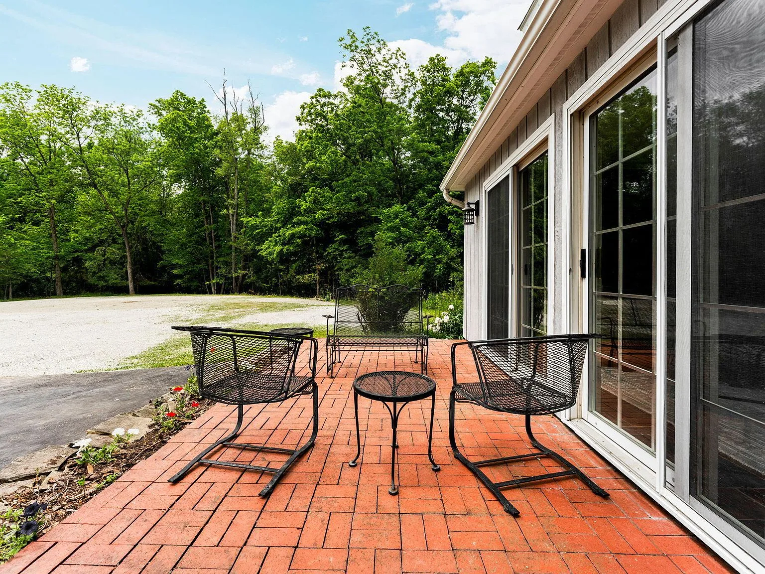 Backyard brick paver patio with rustic siding