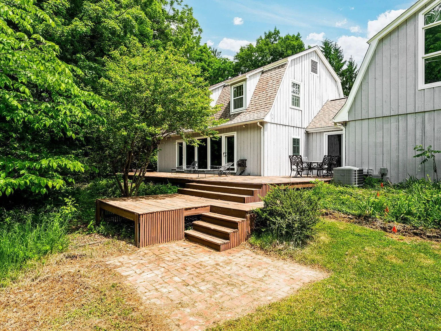 Rear of home showing expansive deck with vertical wood siding