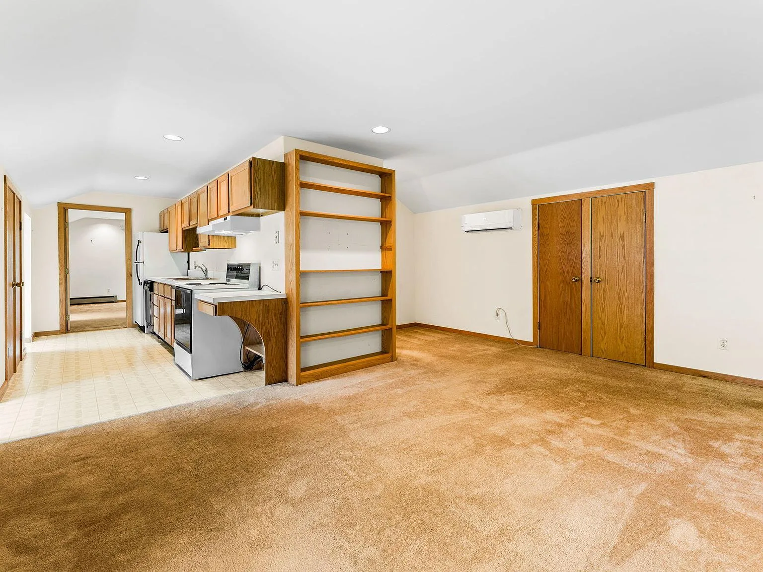 Carriage house kitchen with wood cabinetry and vaulted ceilings