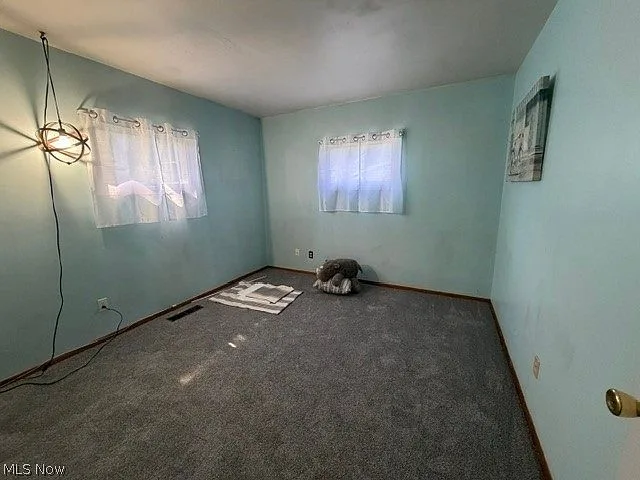 Spare bedroom with light blue walls and white trim