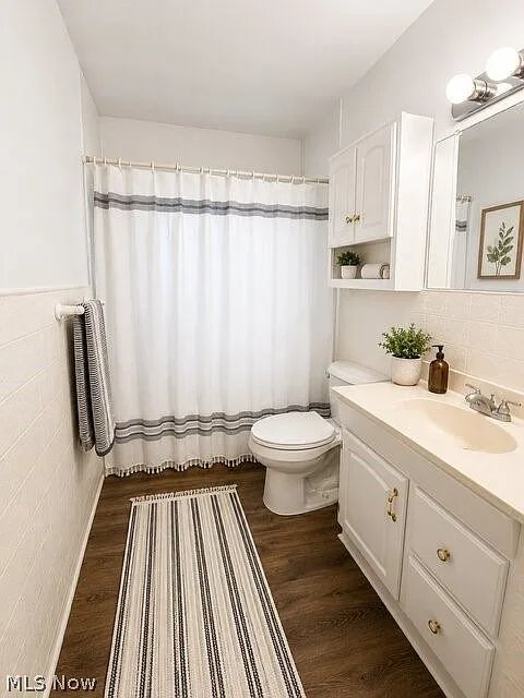 Bathroom with dark wood-look floors and white tile