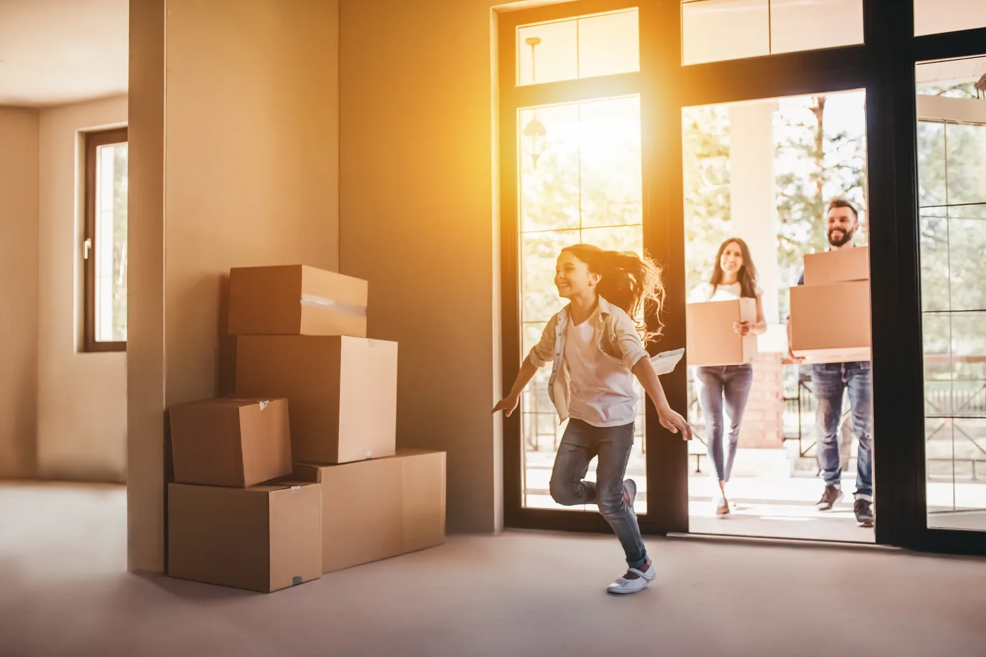 A family walking through the front door of their new home, moving in on a bright sunny day