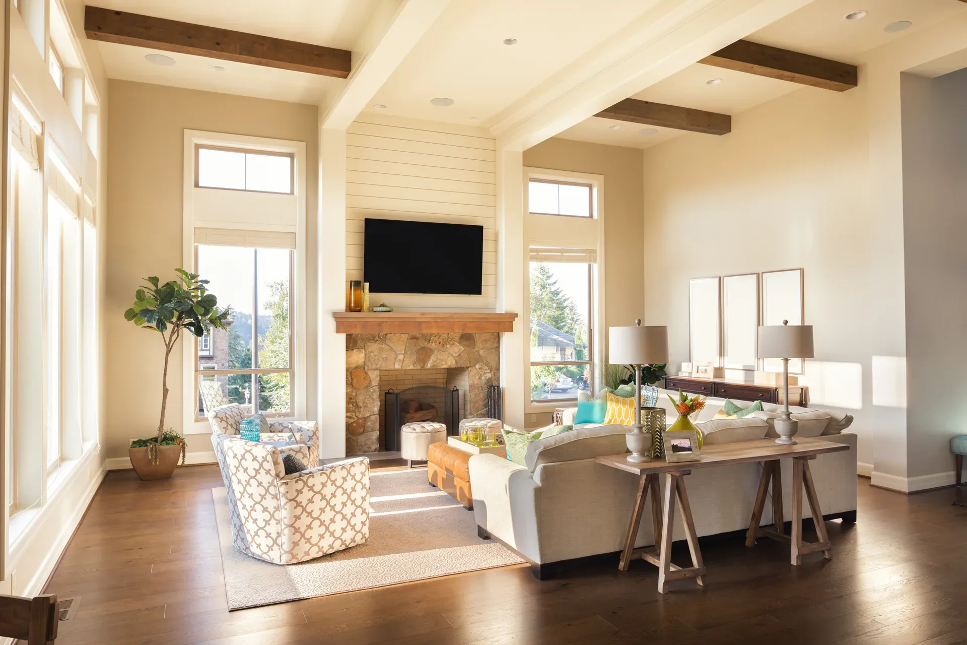 Warm living room interior with a stone fireplace and timber ceiling beams