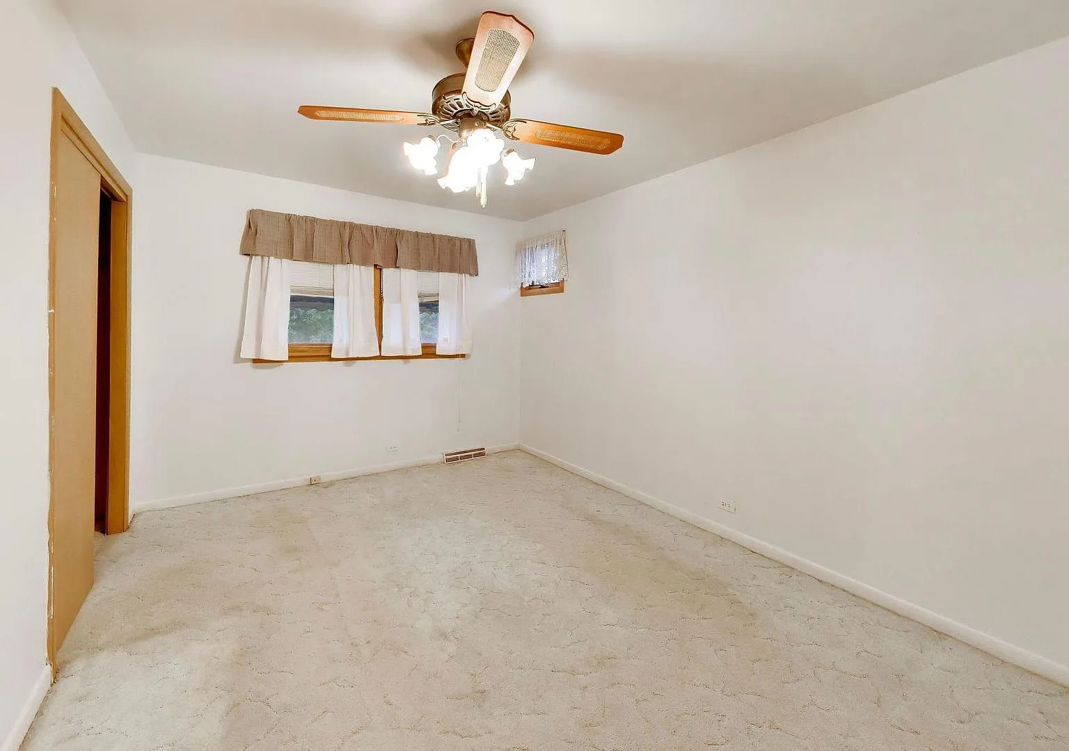 Bedroom with white walls, carpet flooring, and daylight