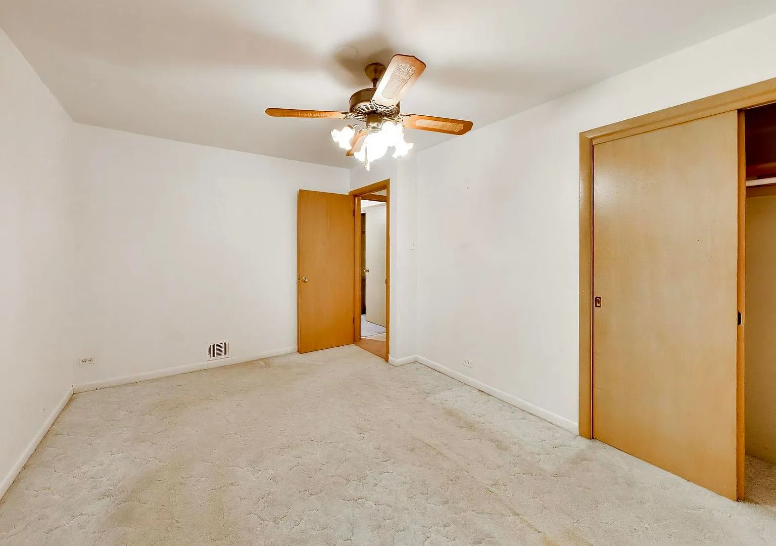 Bedroom with neutral carpet and wood-toned doors