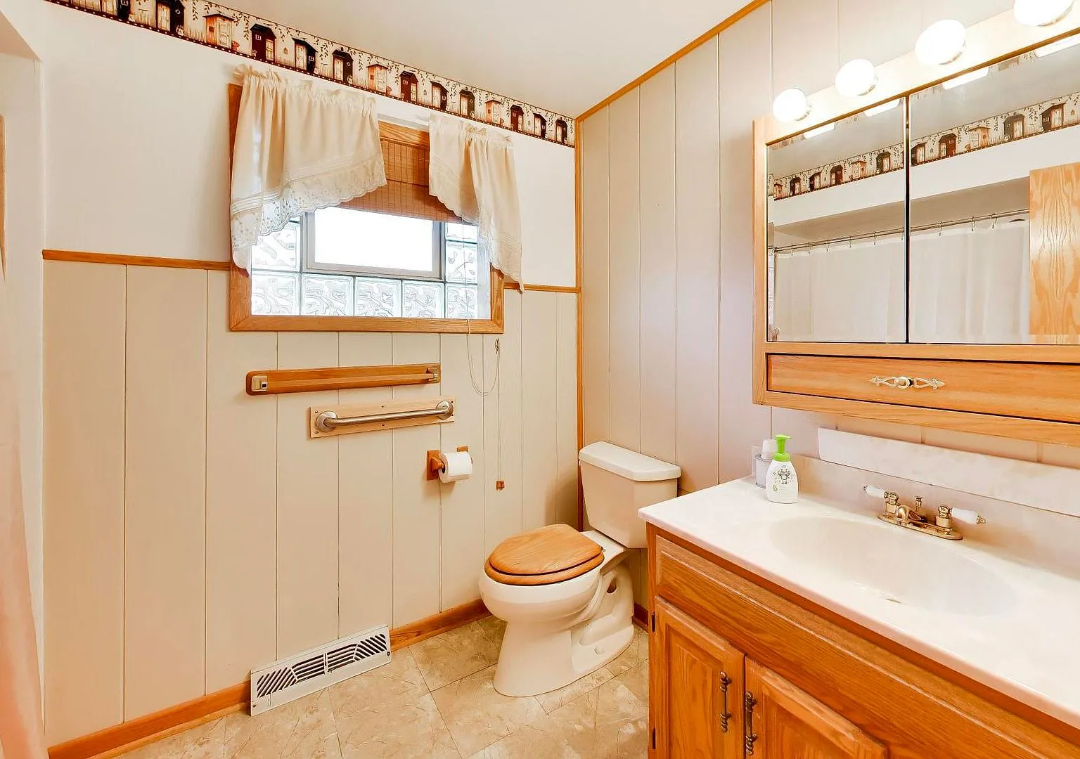 Bathroom with wood vanity and glass block window