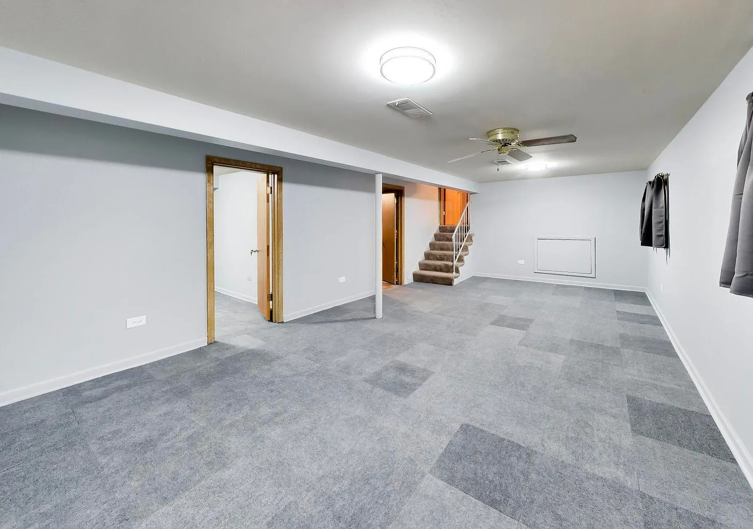 Lower-level flex room with gray carpet tiles
