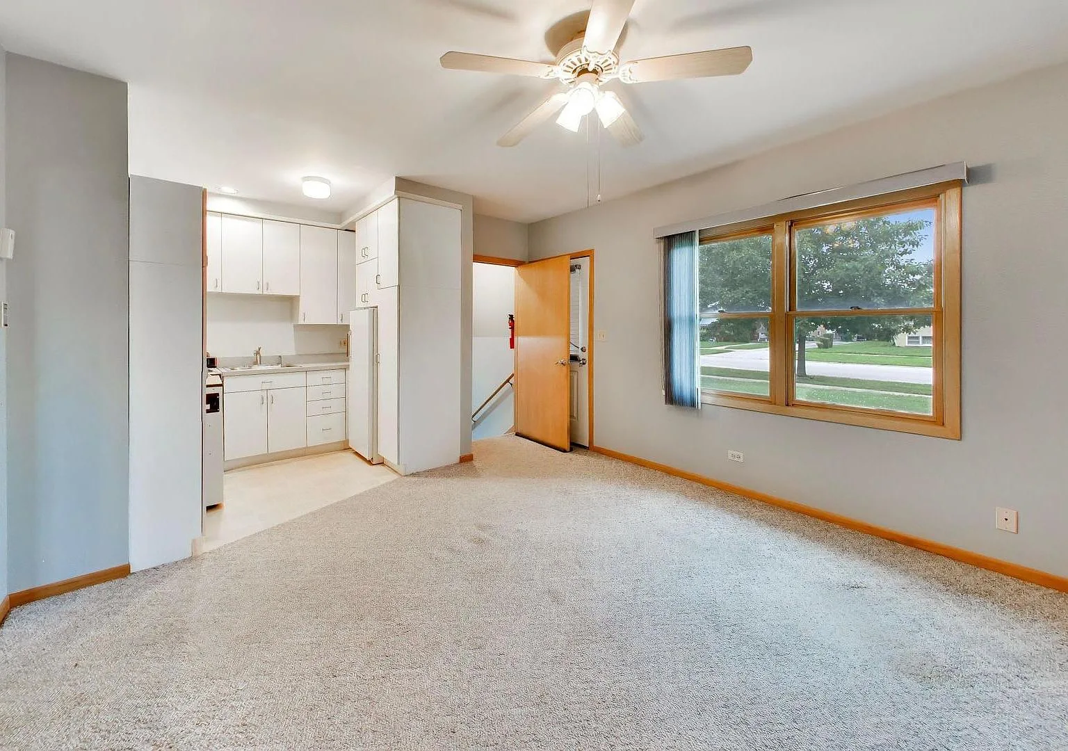 Combined kitchen and living space with white cabinetry