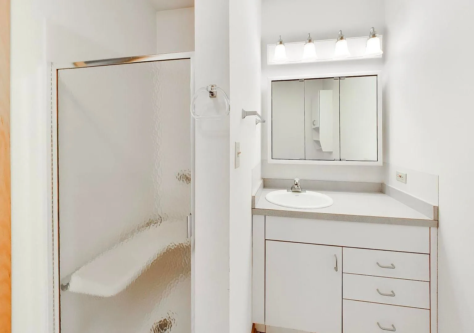 Bathroom with white vanity and glass-door shower
