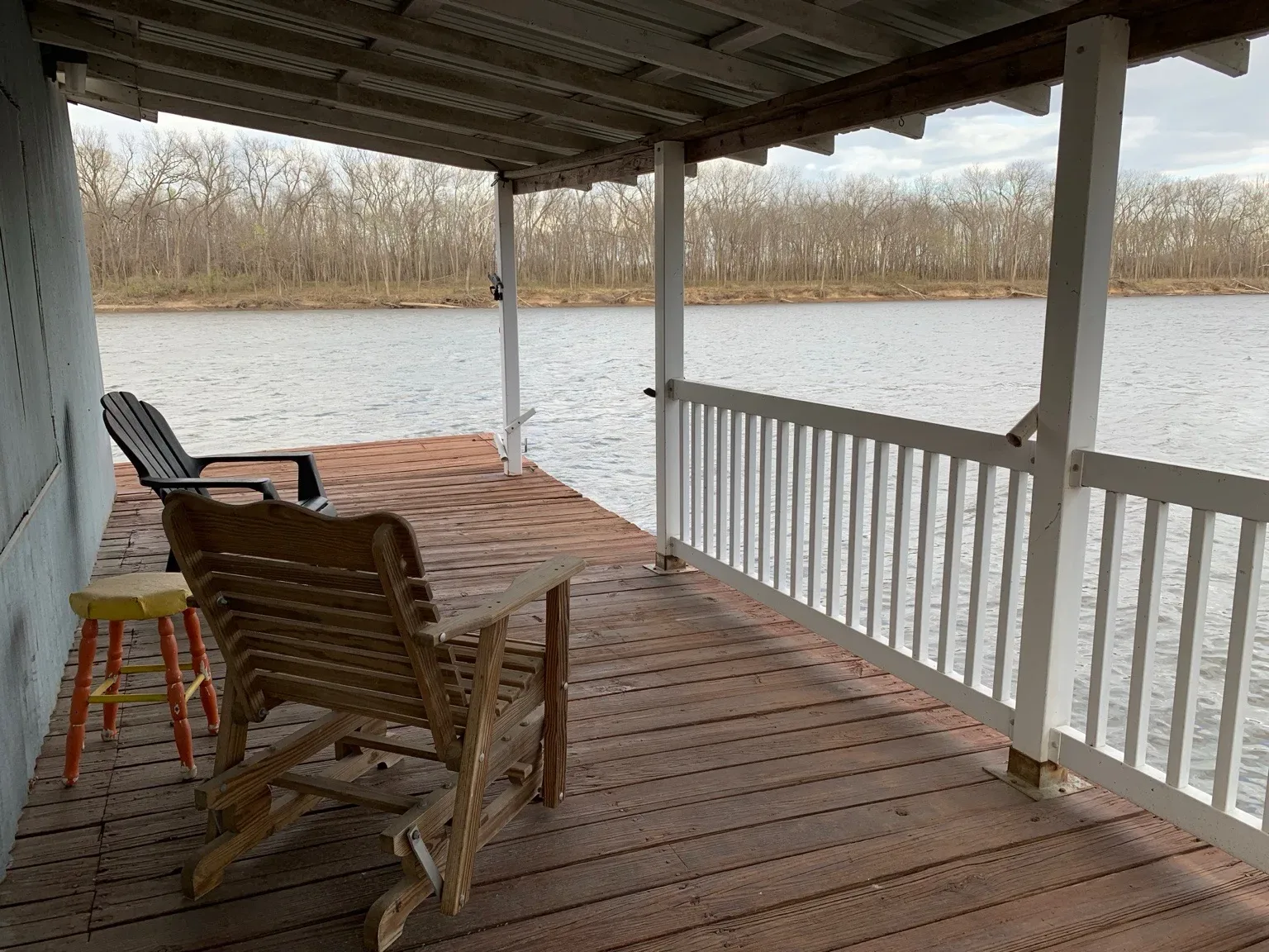 Covered wooden porch overlooking the calm waters of Lake Hudson