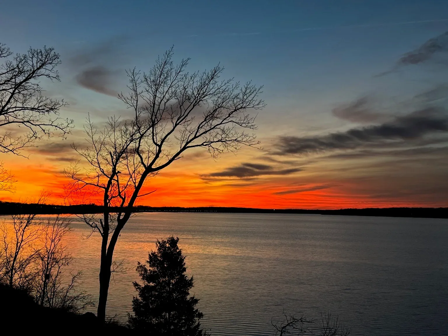 Wide sunset over Lake Hudson framed by a tree